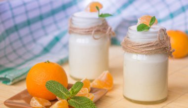 Taze organig doğal beyaz yoğurt mandalina ile cam kavanozlara 