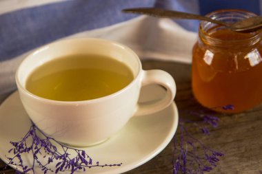 Yeşil çay bir beyaz Kupası ve kavanoz bal ile kaşık ve mavi ki