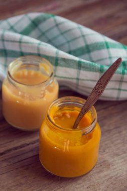 Ahşap masa üzerinde doğal bebek maması ile Cam Kavanoz