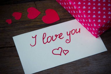 Beyaz kağıt ve kalpli hediye kutusu üzerindeki el yazısıyla seniseviyorum