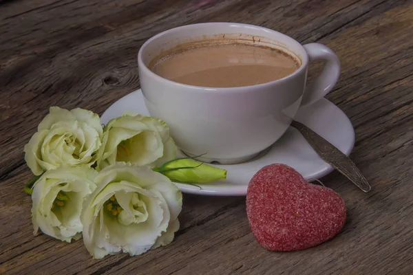 Stilleven met kopje koffie en bloemen Eustoma op houten rug — Stockfoto