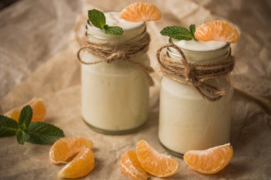 Taze mandalina ve kavanozların içinde nane ile organik yoğurt 