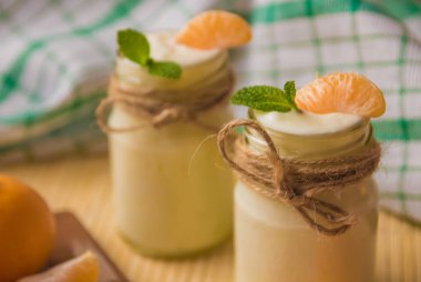 Taze organig doğal beyaz yoğurt mandalina ile cam kavanozlara 