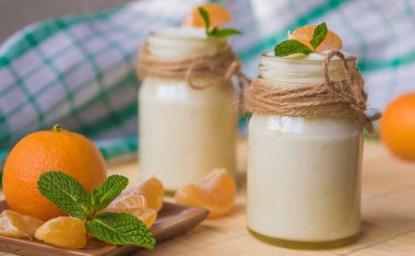 Taze organig doğal beyaz yoğurt mandalina ile cam kavanozlara 