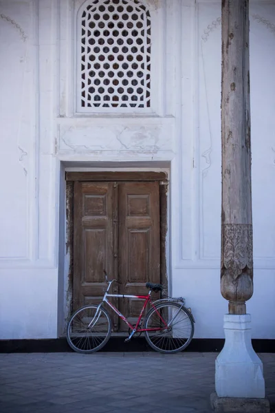 Παλιά ξύλινη πόρτα και bycicle στη Μπουχάρα, — Φωτογραφία Αρχείου