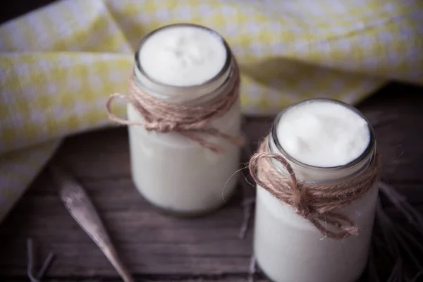 Joghurt in Gläsern auf dem Holztisch mit Serviette, Löffel und getrockneten — Stockfoto