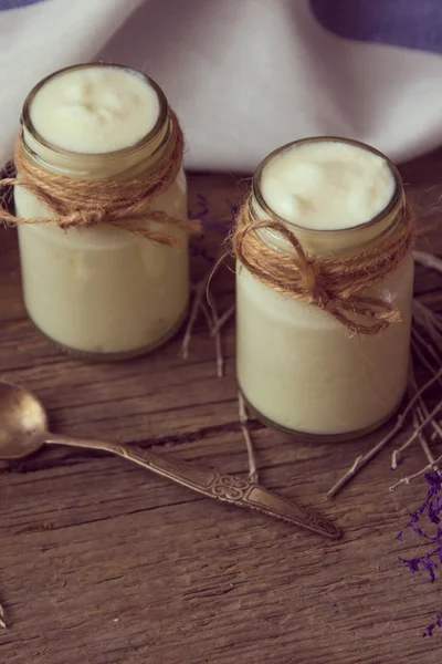 Iogurte em frascos na mesa de madeira com guardanapo, colher e seco — Fotografia de Stock