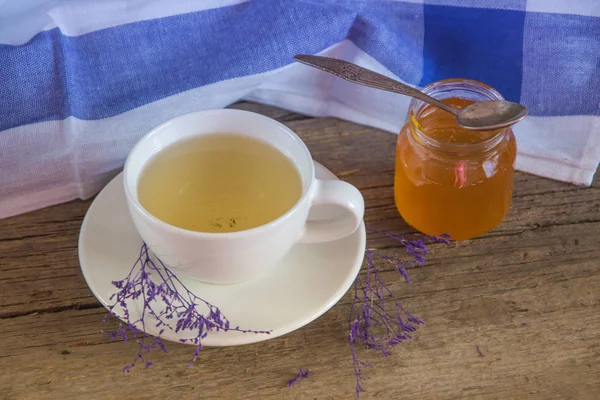 Thé vert dans une tasse blanche et pot de miel avec cuillère et ki bleu — Photo