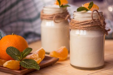 Taze organig doğal beyaz yoğurt mandalina ile cam kavanozlara 