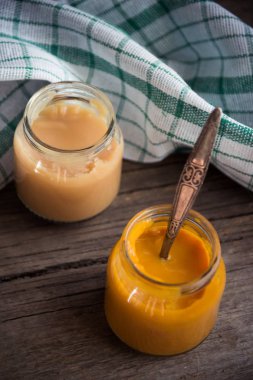 Ahşap masa üzerinde doğal bebek maması ile Cam Kavanoz