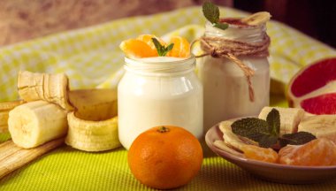 Taze organik doğal beyaz yoğurt mandalina ile cam kavanozlara 