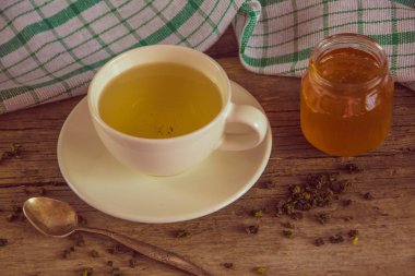 Yeşil çay bir beyaz Kupası ve kavanoz bal ile kaşık ve yeşil k