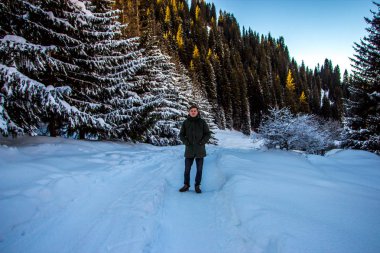 Genç adam kış dağlarda yürüyüş