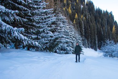 Genç adam kış dağlarda yürüyüş