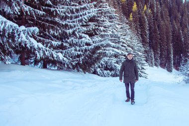 Genç adam kış dağlarda yürüyüş