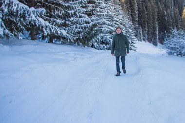 Genç adam kış dağlarda yürüyüş