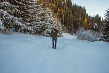 Genç adam kış dağlarda yürüyüş