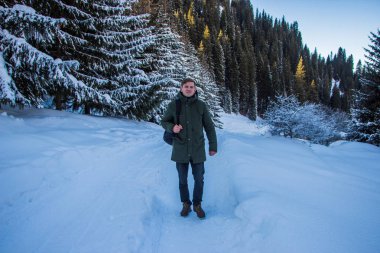 Genç adam kış dağlarda yürüyüş