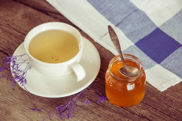 Chá verde em uma xícara branca e jarra de mel com colher e ki azul — Fotografia de Stock