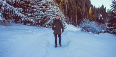 Genç adam kış dağlarda yürüyüş