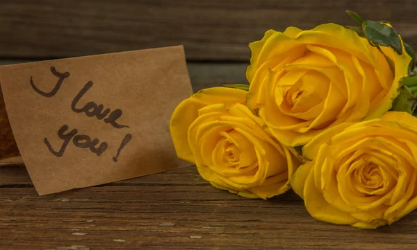 Жовті троянди, подарункова коробка та листівка з текстом, який я люблю — стокове фото