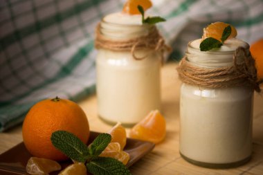 Taze organig doğal beyaz yoğurt mandalina ile cam kavanozlara 
