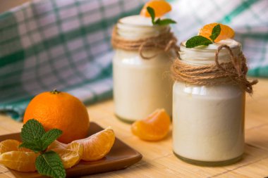 Taze organig doğal beyaz yoğurt mandalina ile cam kavanozlara 