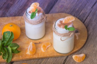 Taze organig doğal beyaz yoğurt mandalina ile cam kavanozlara 