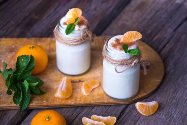 Taze organig doğal beyaz yoğurt mandalina ile cam kavanozlara 
