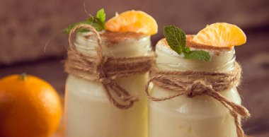 Taze organig doğal beyaz yoğurt mandalina ile cam kavanozlara 