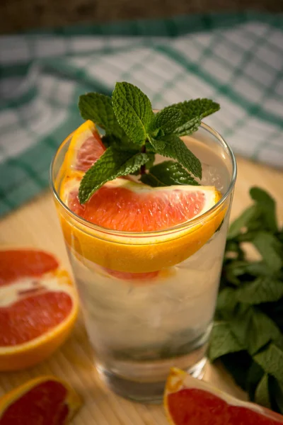 Eau glacée, menthe verte et orange rouge dans un verre — Photo