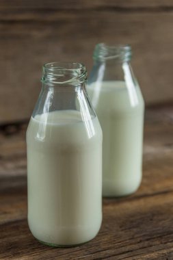 ahşap arka plan üzerinde bir şişe süt