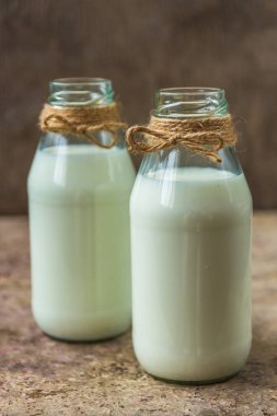 ahşap arka plan üzerinde bir şişe süt