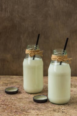 ahşap arka plan üzerinde bir şişe süt