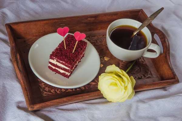 Ontbijt op bed. Beker, koffie, rode, velours, taart en bloem — Stockfoto
