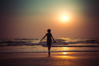 Güzel bir genç kız Hindistan, Goa, Ar Sunset'teki silüeti