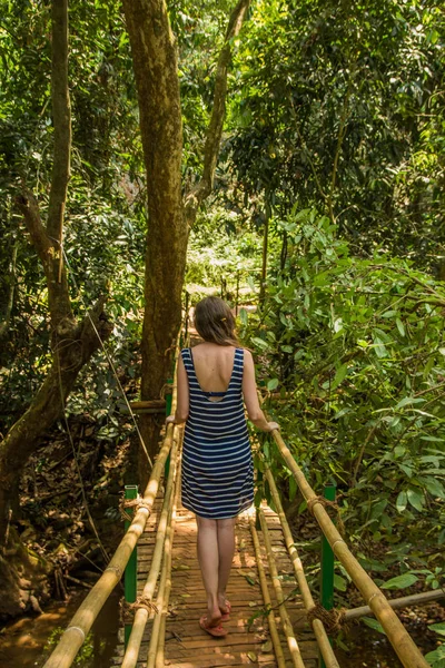 Young woman in the jungle on the bridge in tropical spice planta