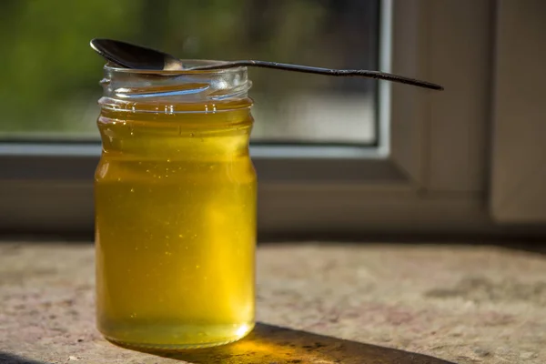 Orgánica miel pura en tarro en alféizar ventana — Foto de Stock