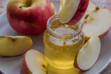 Cam Kavanoz ve Kırmızı elma plaka üzerinde organik bal