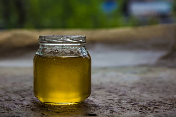 Honung i burk och fönster med grönt på backcground — Stockfoto