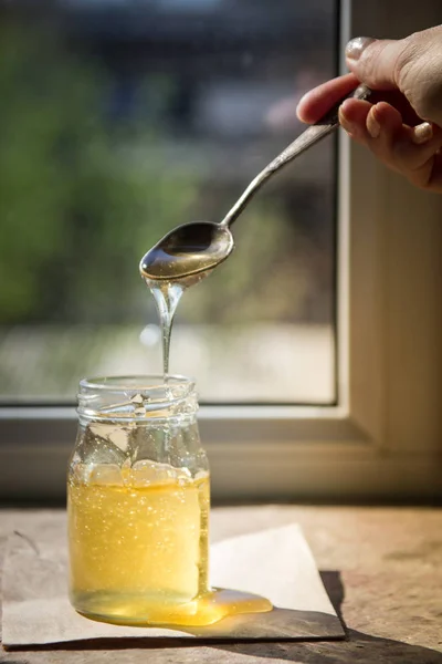 Csöpögő-ból egy kanál méz. Szerves tiszta méz jar — Stock Fotó