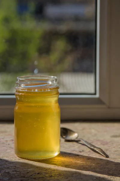 Biologische zuivere honing in pot op de vensterbank — Stockfoto