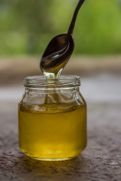 Μέλι σε βάζο και παράθυρο με πράσινο για backcground — Φωτογραφία Αρχείου