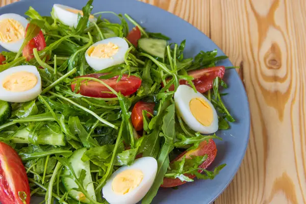 Fresh green salad with arugula, tomatoes, eggs and cucumber — Stock Photo, Image