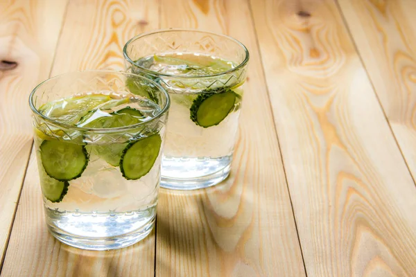 Su ile salatalık ve ahşap masa üzerinde Limon Detoks. Salatalık le