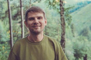 Genç adam portre dağlarda yaz ormandaki