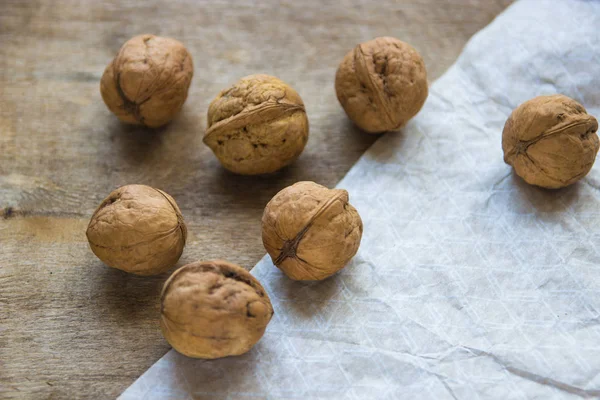 Vlašské ořechy na dřevěný stůl. Celé čerstvé vlašské ořechy — Stock fotografie
