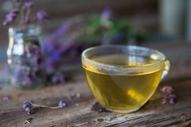 Bitkiler ile yeşil çay. Ahşap adam üzerinde kekik çayı