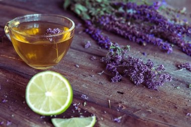 Bitkiler ve kireç ile yeşil çay. Ahşap üzerine kekik çayı 