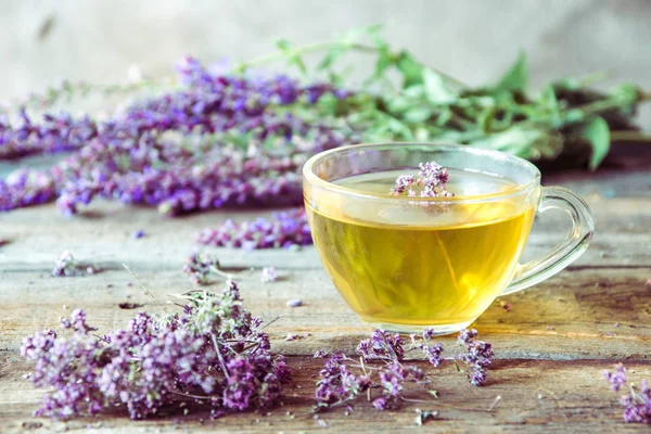 Bitkiler ile yeşil çay. Ahşap adam üzerinde kekik çayı